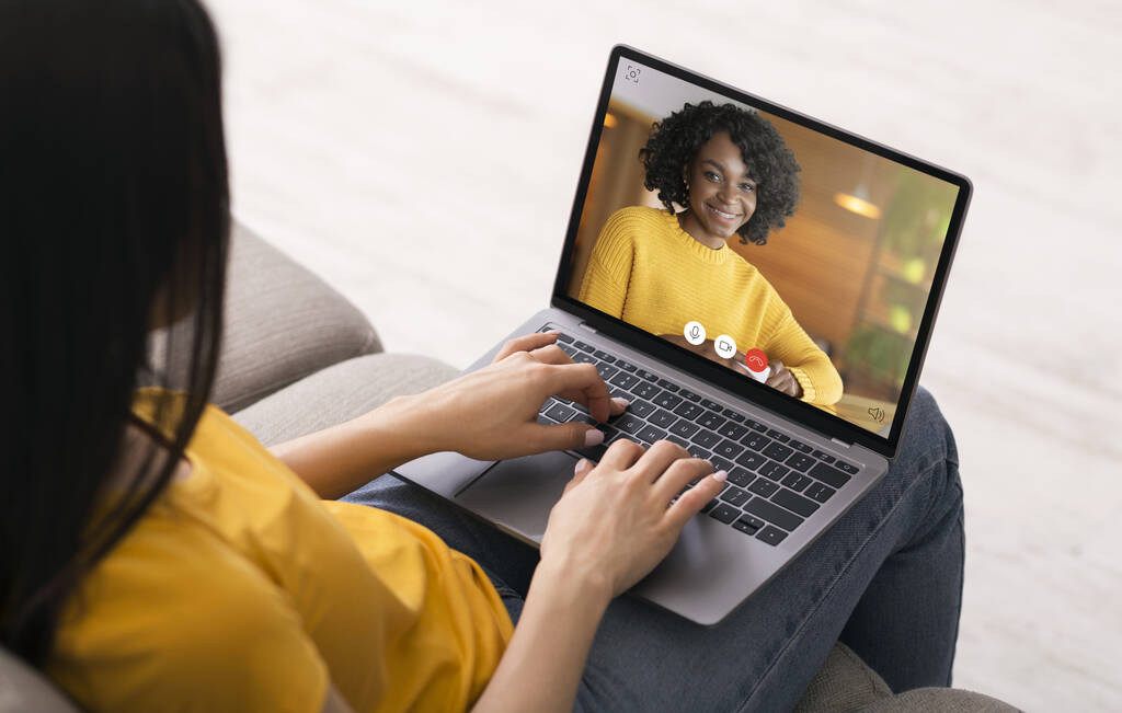 Woman Calling Friend Using Laptop Chatting Online At Home